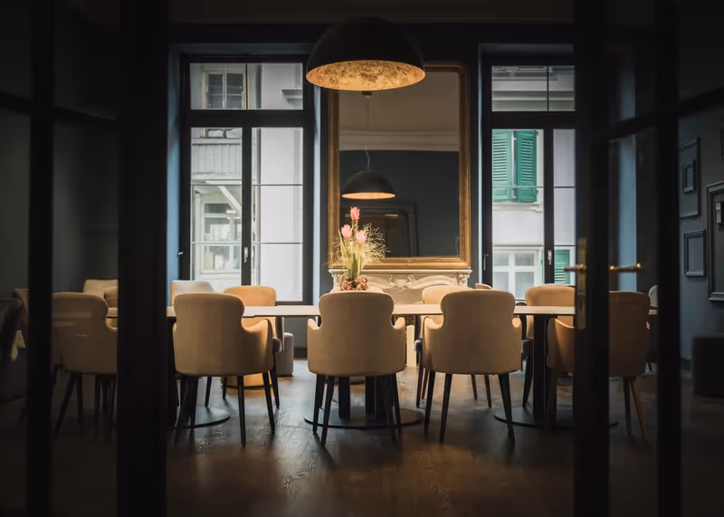 Konferenzbereich mit grossem Tisch und gepolsterten Stühlen im The HEY HOTEL