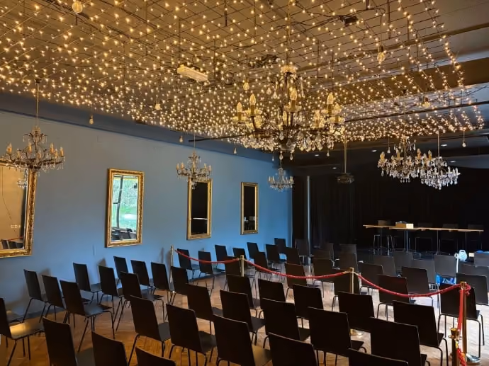 Spiegelsaal mit Stuhlreihen, Bühne und Sternenhimmel