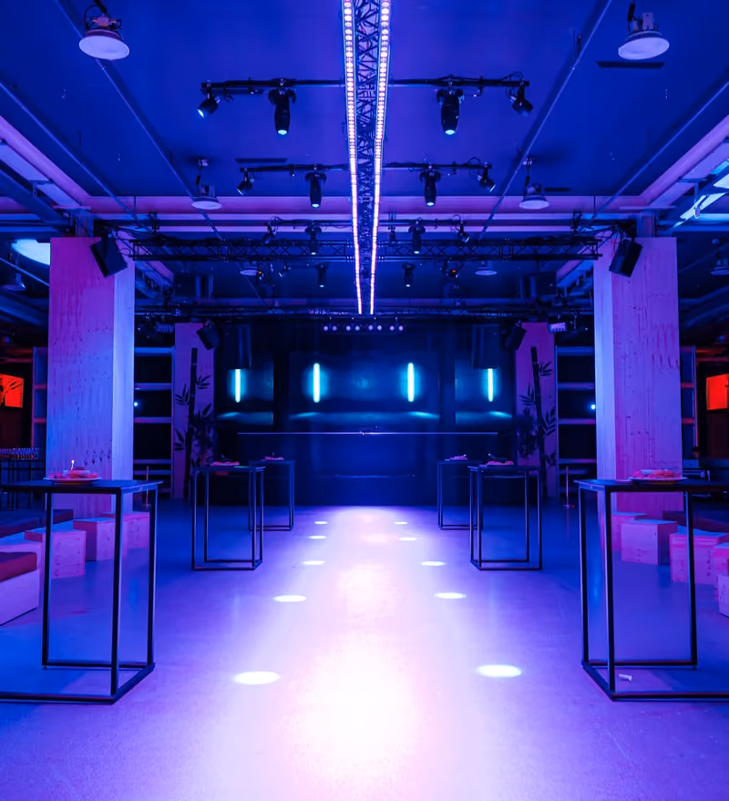 CUBE mit Stehtischen und blau-violetter Lichtgestaltung