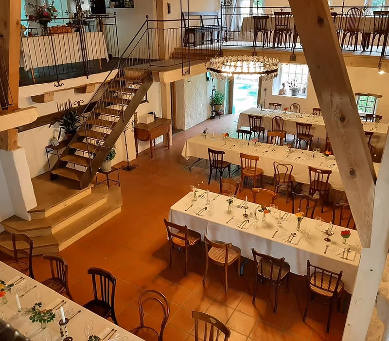 Innenraum der Cacis Mühle mit Galerie und gedeckten Tischen