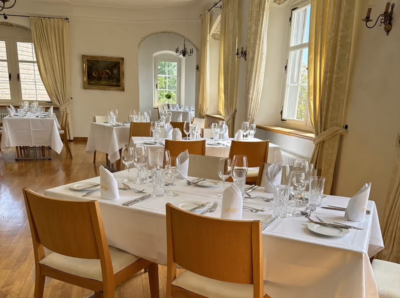 Gedeckte Tische im hellen Schlappritzi-Saal von Schloss Weinstein
