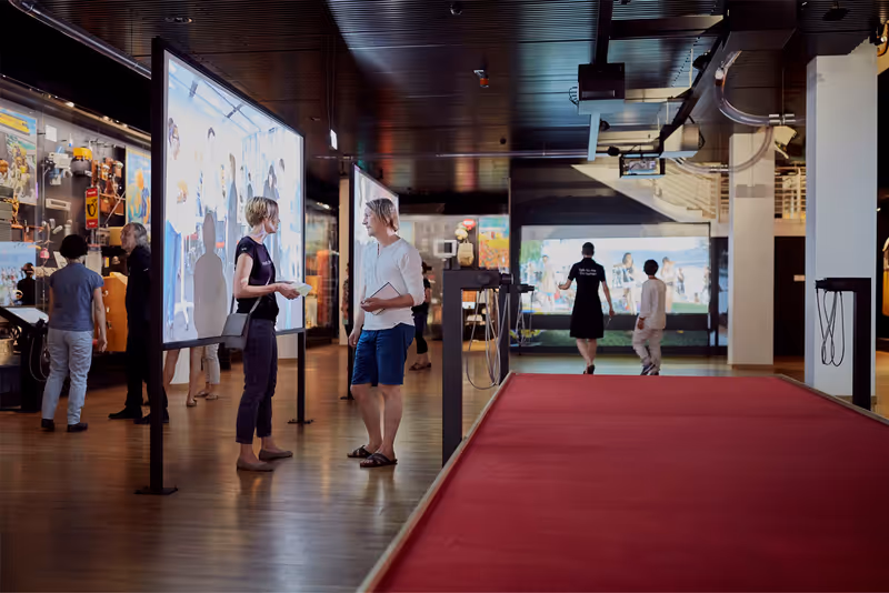 Ausstellung im Museum für Kommunikation mit rotem Teppich und Videoprojektionen