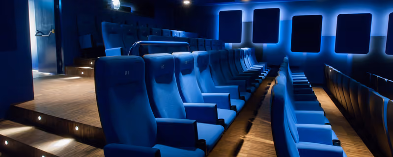 Blauer Kinosaal mit gepolsterten Sitzreihen im kult.kino atelier