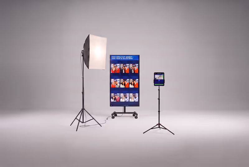Professionelles IMMERSA KI-Fotobox Setup für Events und Messen in der DACH-Region. Rollbarer TV-Displayständer mit Live-Galerie, Softbox-Beleuchtung und iPad-Station auf Stativ. Buchbar für Firmenevents, Hochzeiten und Markenaktivierungen in Deutschland, Österreich und der Schweiz.