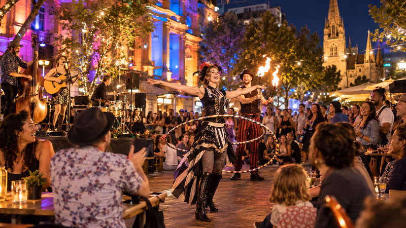 Colourful outdoor Fringe performances and festival crowd in Adelaide at dusk. AI-generated image.